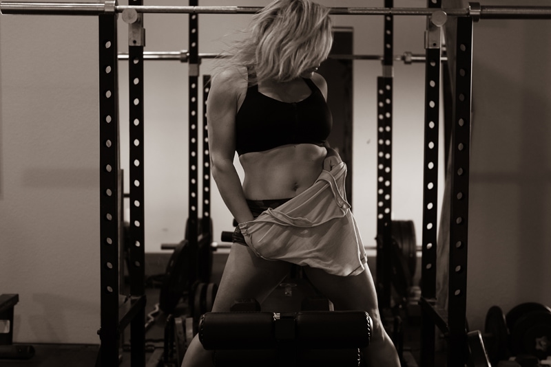 Boudoir Photography, woman in gym attire stands before equipment